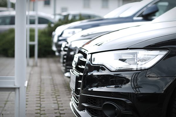 Aneinanderreihung verschiedener Audi Modelle auf einem Parkplatz.
