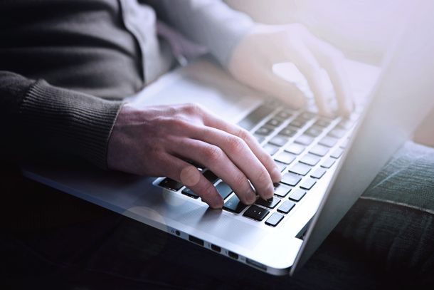 Mann sitzt am Laptop und will etwas online buchen